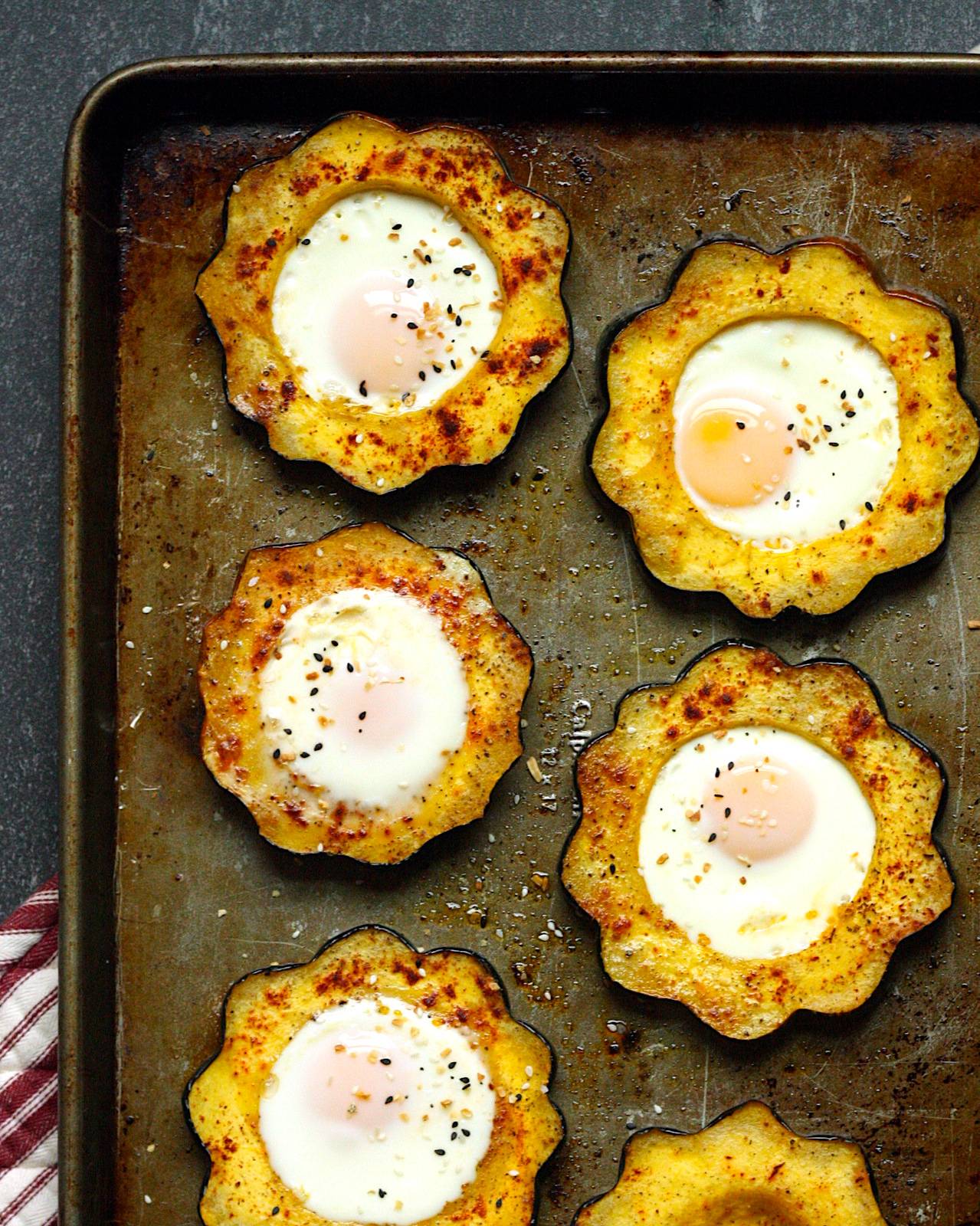 Sheet pan with acorn squash rings around cooked eggs